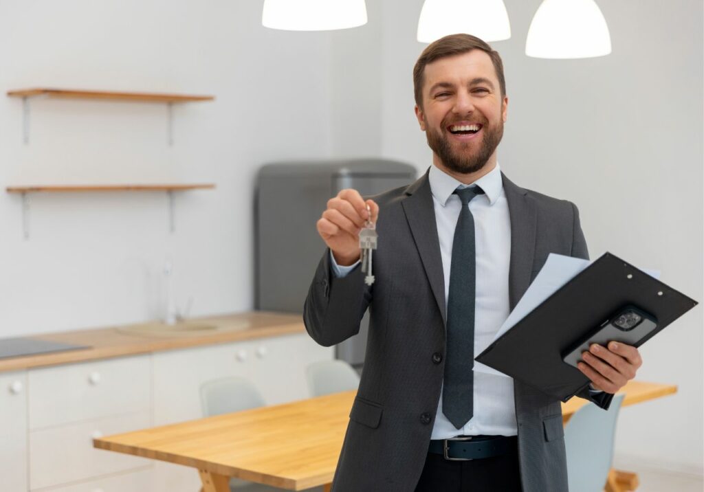 Agent immobilier souriant tenant des clés dans un appartement moderne, représentant un investissement locatif réussi