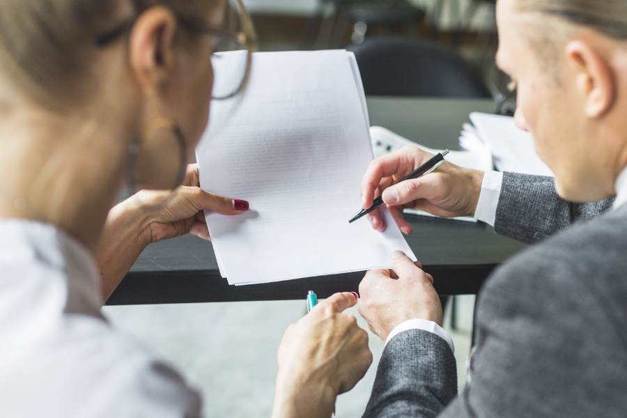 Deux personnes en train de signer un contrat.
