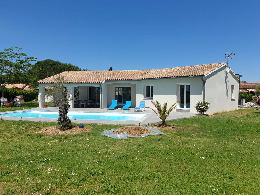 Vue arrière d’une maison avec piscine et terrasse carrelée après agrandissement.